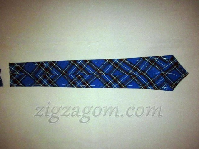 Ткань на основной детали галстука подворачивается на обратную сторону и промётывается