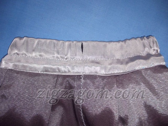 Накладываем полученный край на шов притачивания кокетки с изнаночной стороны юбки немного ниже шва, прострачиваем по линии притачивания