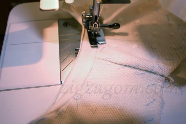 С помощью оверлочной лапки на швейной машине отстрочить бейку близко к шву притачивания